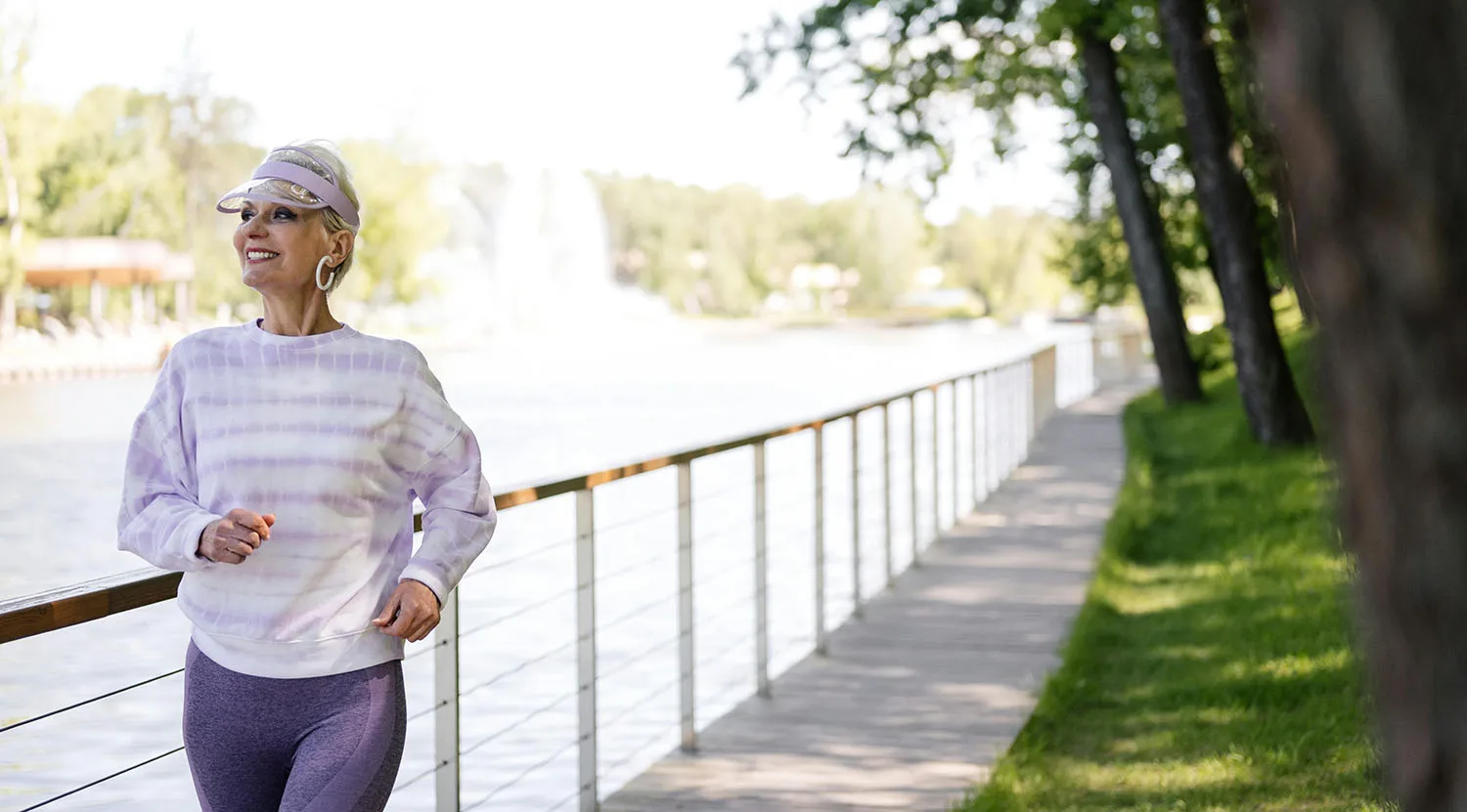 Senior woman enjoying a walk along a scenic waterfront boardwalk.