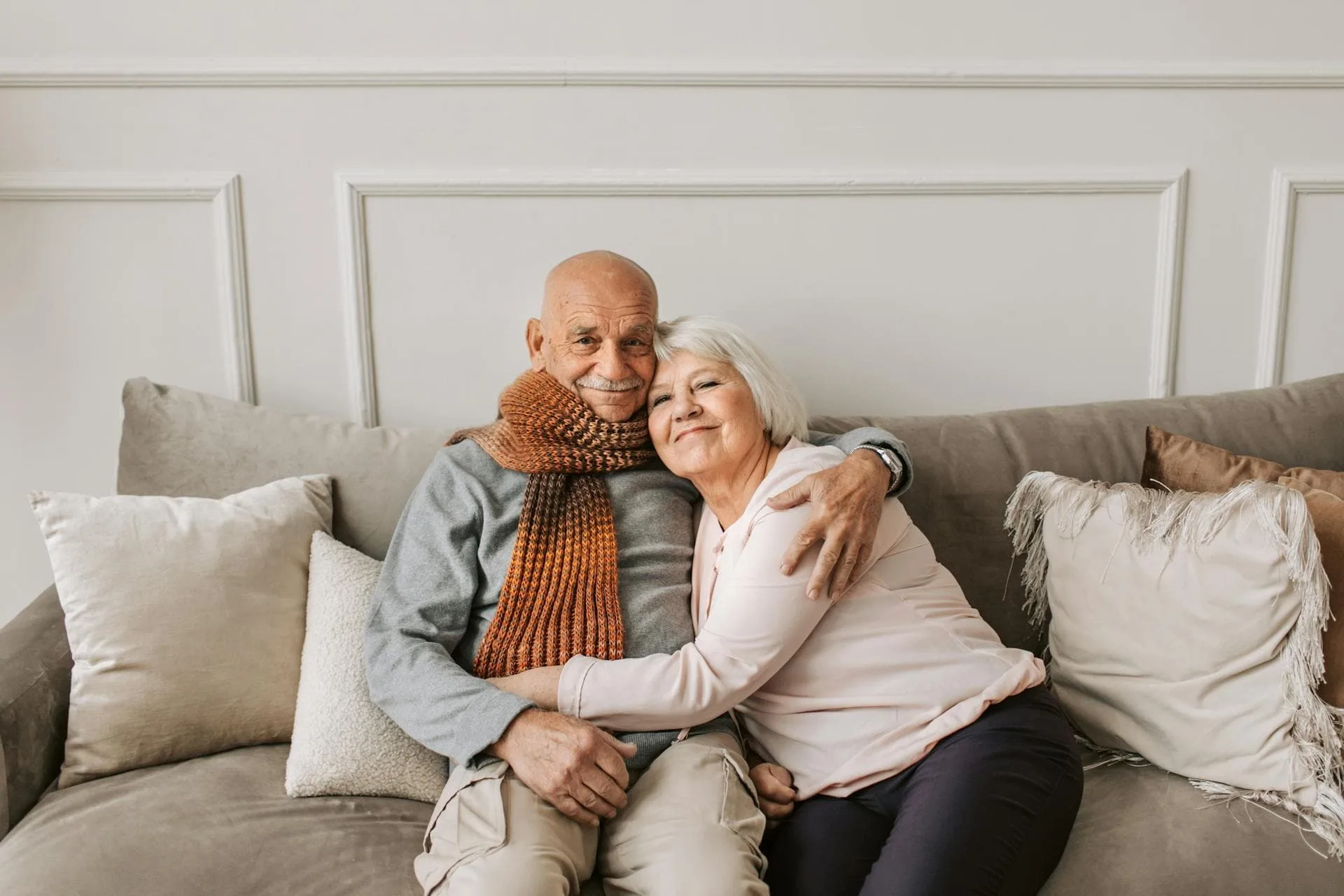 Happy senior couple embracing on a cozy sofa.