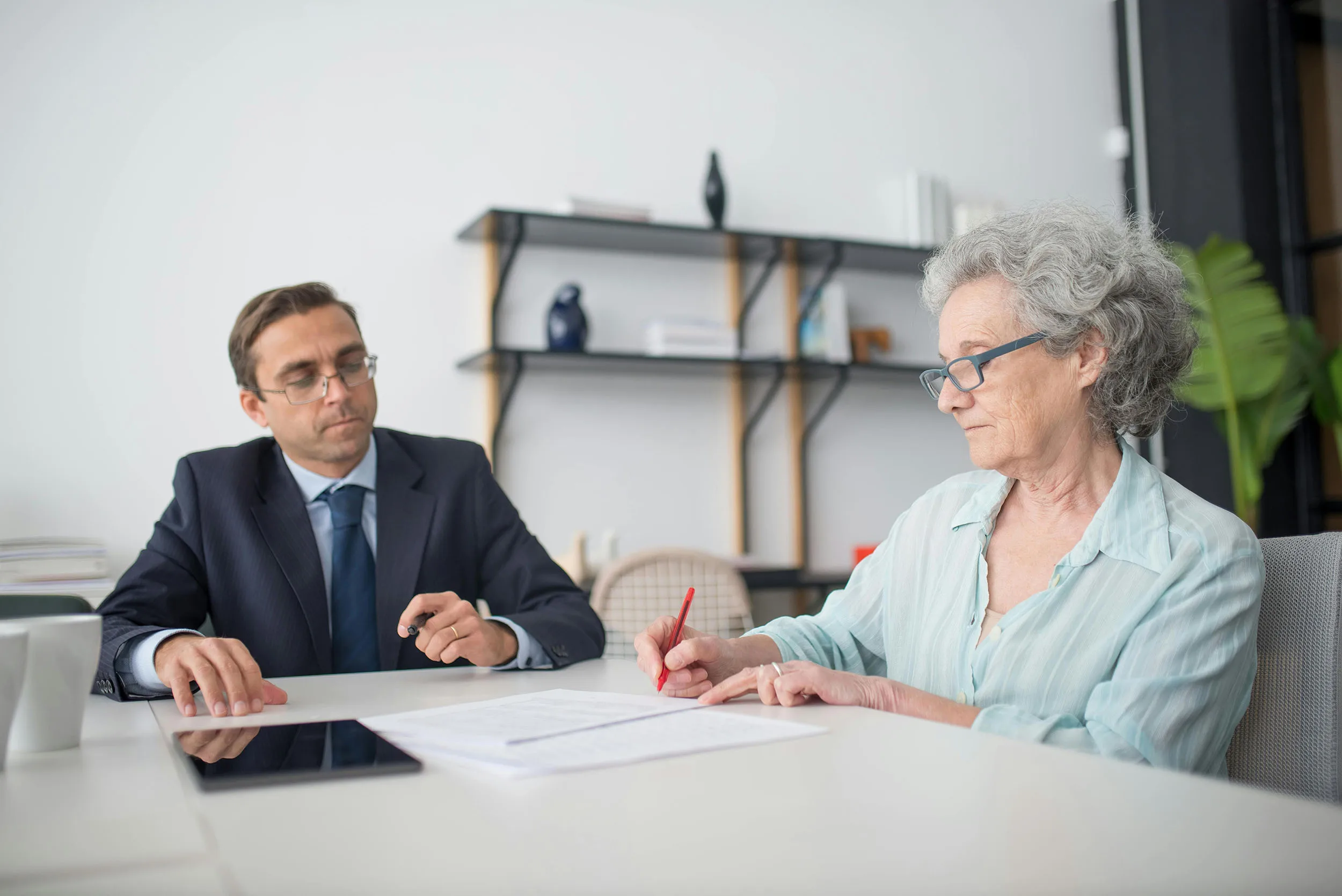 Senior woman consulting with a professional in an office setting.