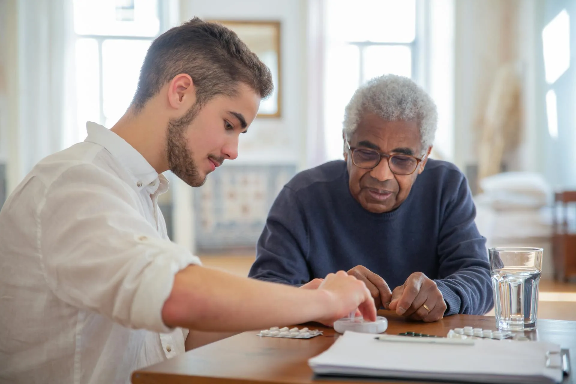 Senior man receiving assistance with medication management.